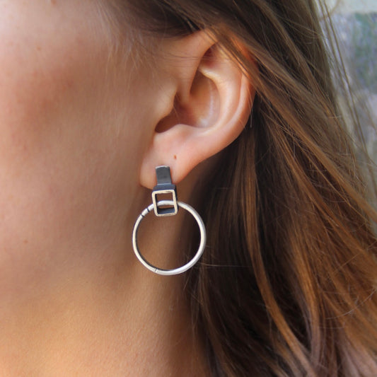 A pair of silver oxidized and brushed finish earrings with a geometric design