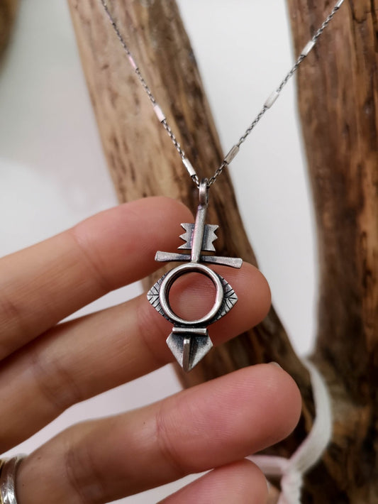 A silver necklace with a geometric-patterned pendant, featuring a combination of Morrocan and Mexican inspiration.