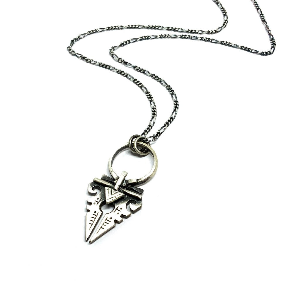 A sterling silver necklace with an oxidized and brushed finish, featuring a pendant with a strength symbol design.