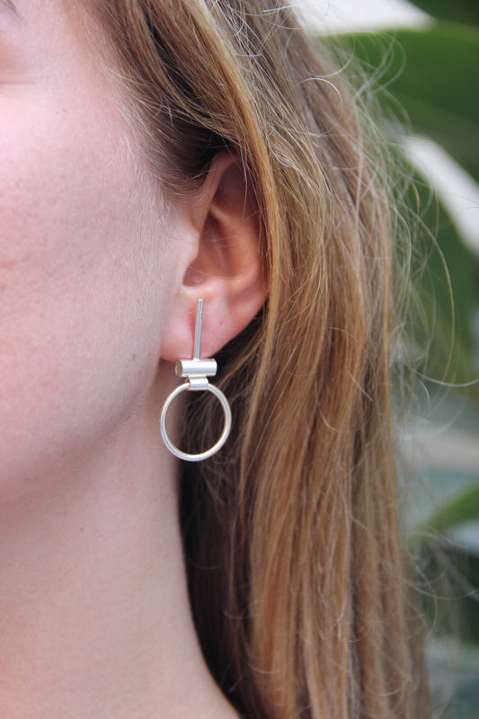 A pair of silver hoop earrings with a brushed finish, featuring a simple and elegant design.