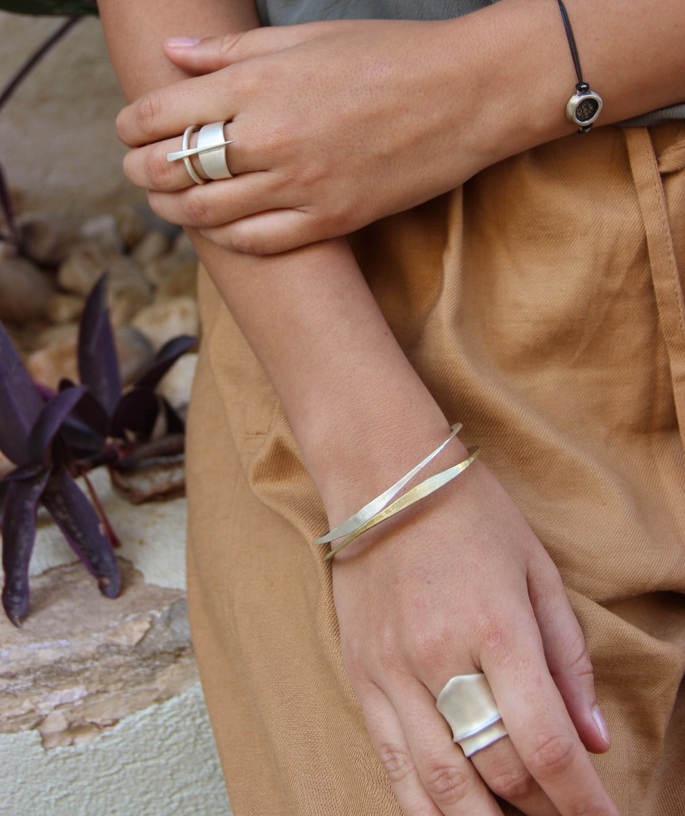 A silver bracelet with a brushed finish