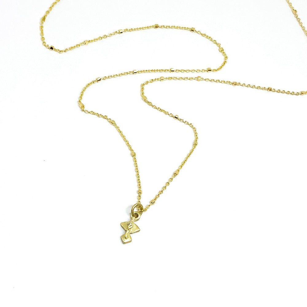 A golden necklace with a white diamond pendant 