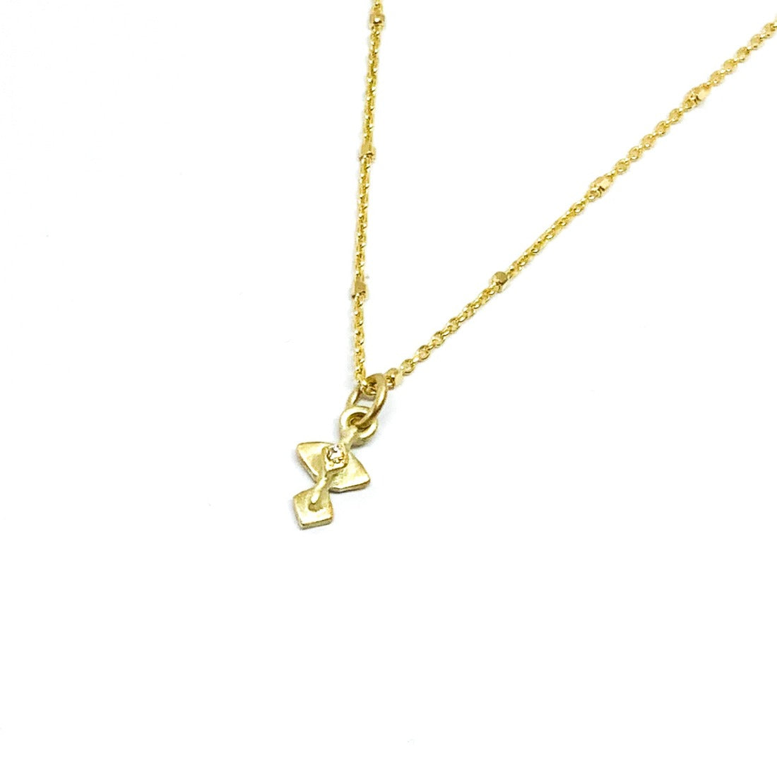 A golden necklace with a white diamond pendant