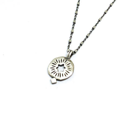 A silver pendant on a chain with a cut out star 