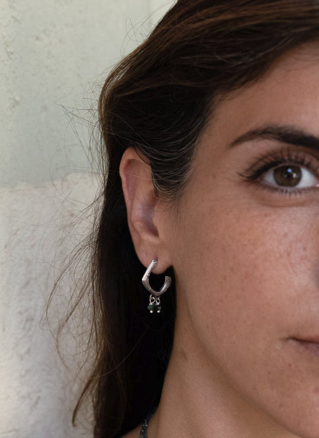 A pair of sterling silver oxidized and brushed finish earrings with turquoise accents and decorative stones.