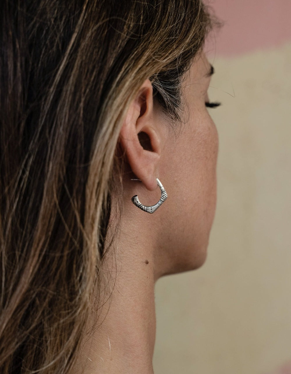 A pair of silver oxidized and brushed finish earrings with a geometric pattern, handcrafted.