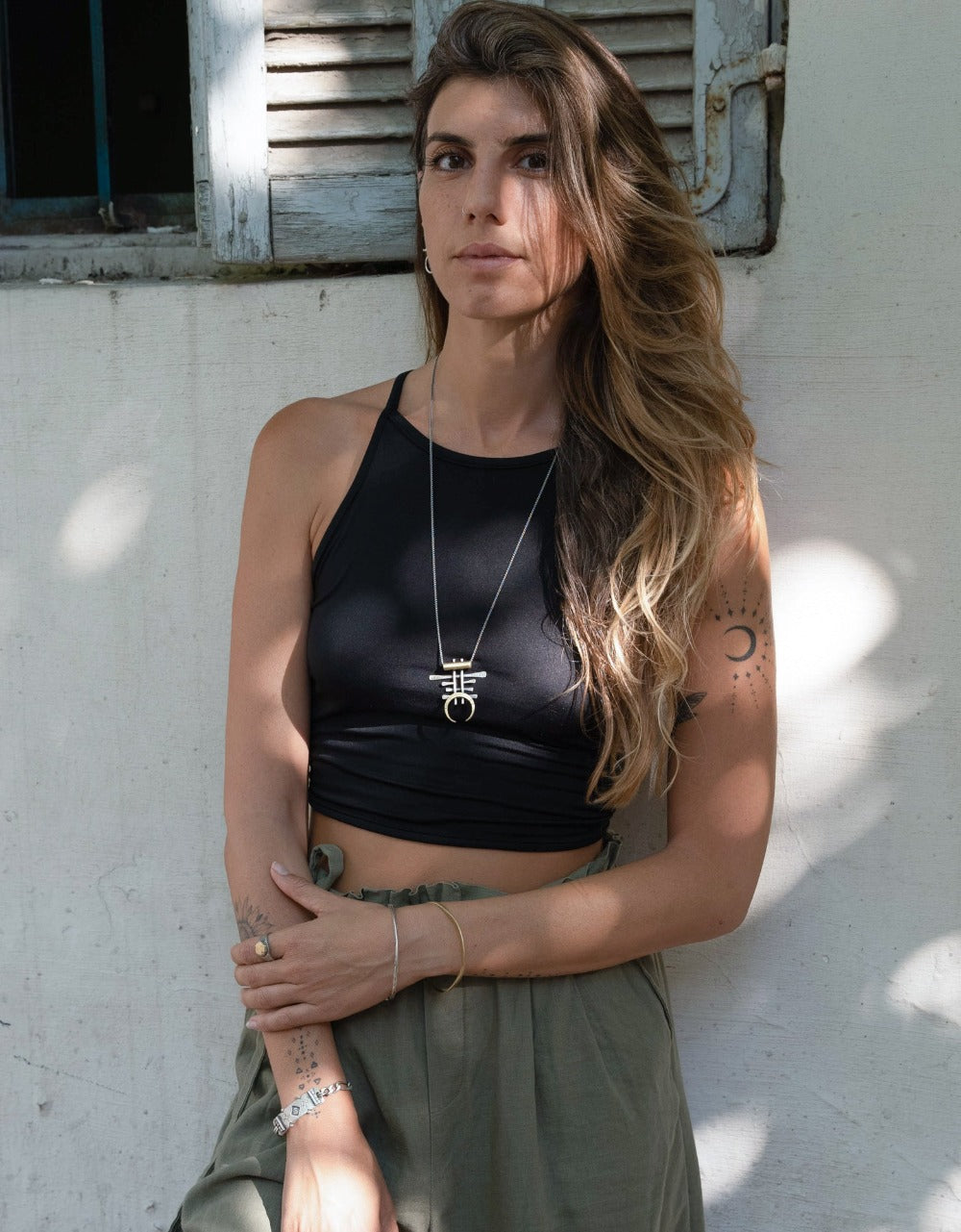 A necklace with a unique geometric pendant made of silver and brass, featuring an oxidized and brushed finish.