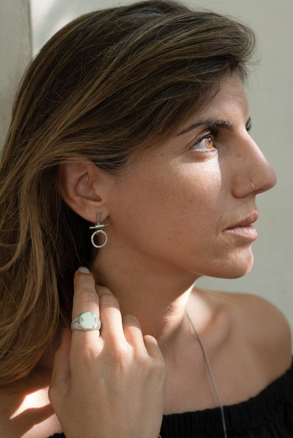 A pair of silver and brass earrings with a geometric design