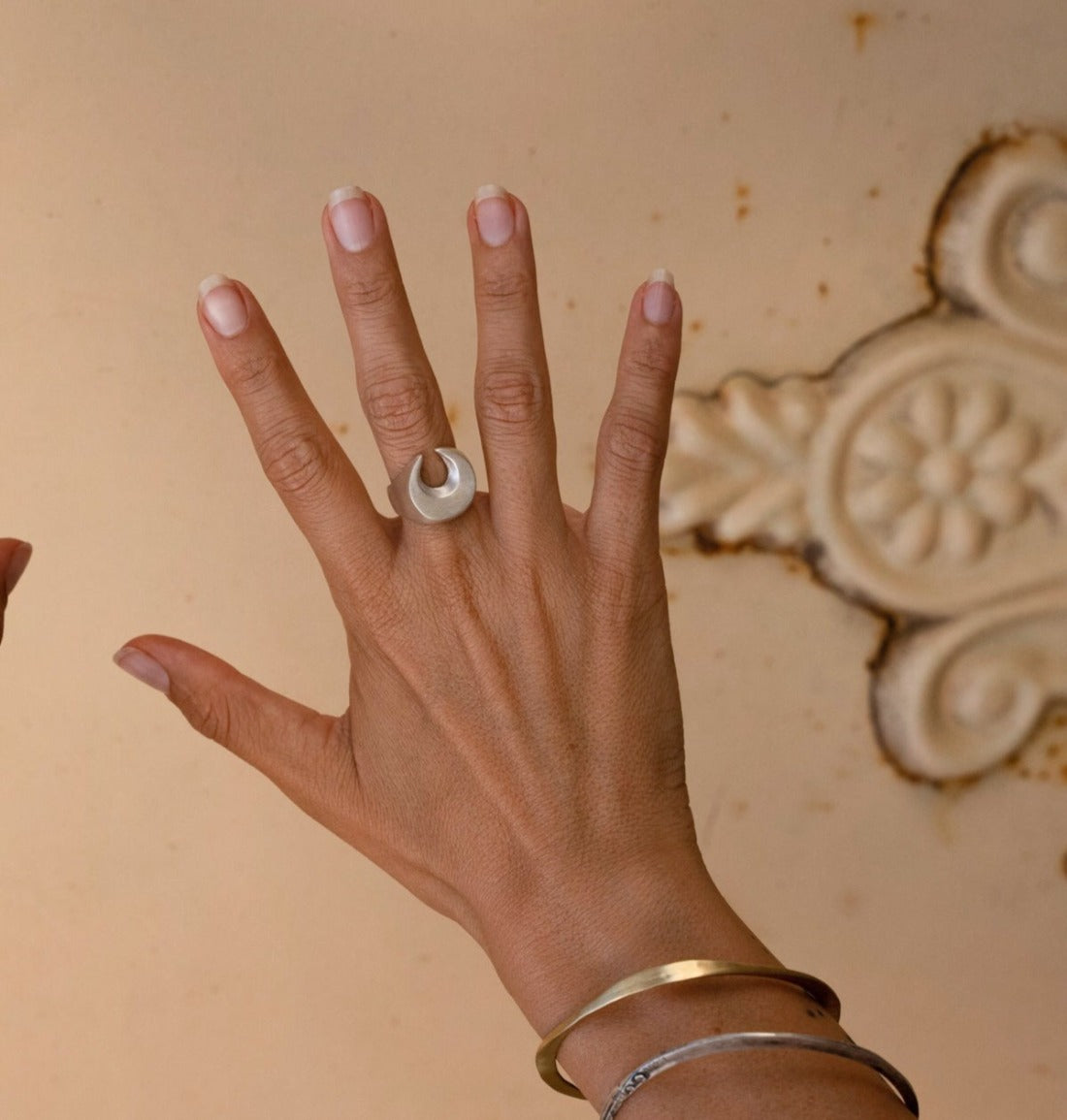 A silver signet ring with a brushed finish, featuring a crescent moon design.