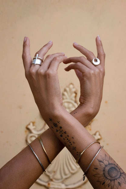 A silver signet ring with a brushed finish, featuring a crescent moon design.