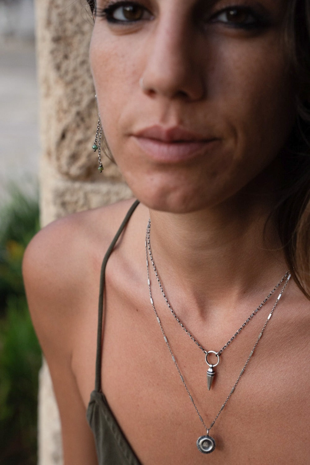 A sterling silver pendulum necklace with a brushed finish and a chain loop at the top.
