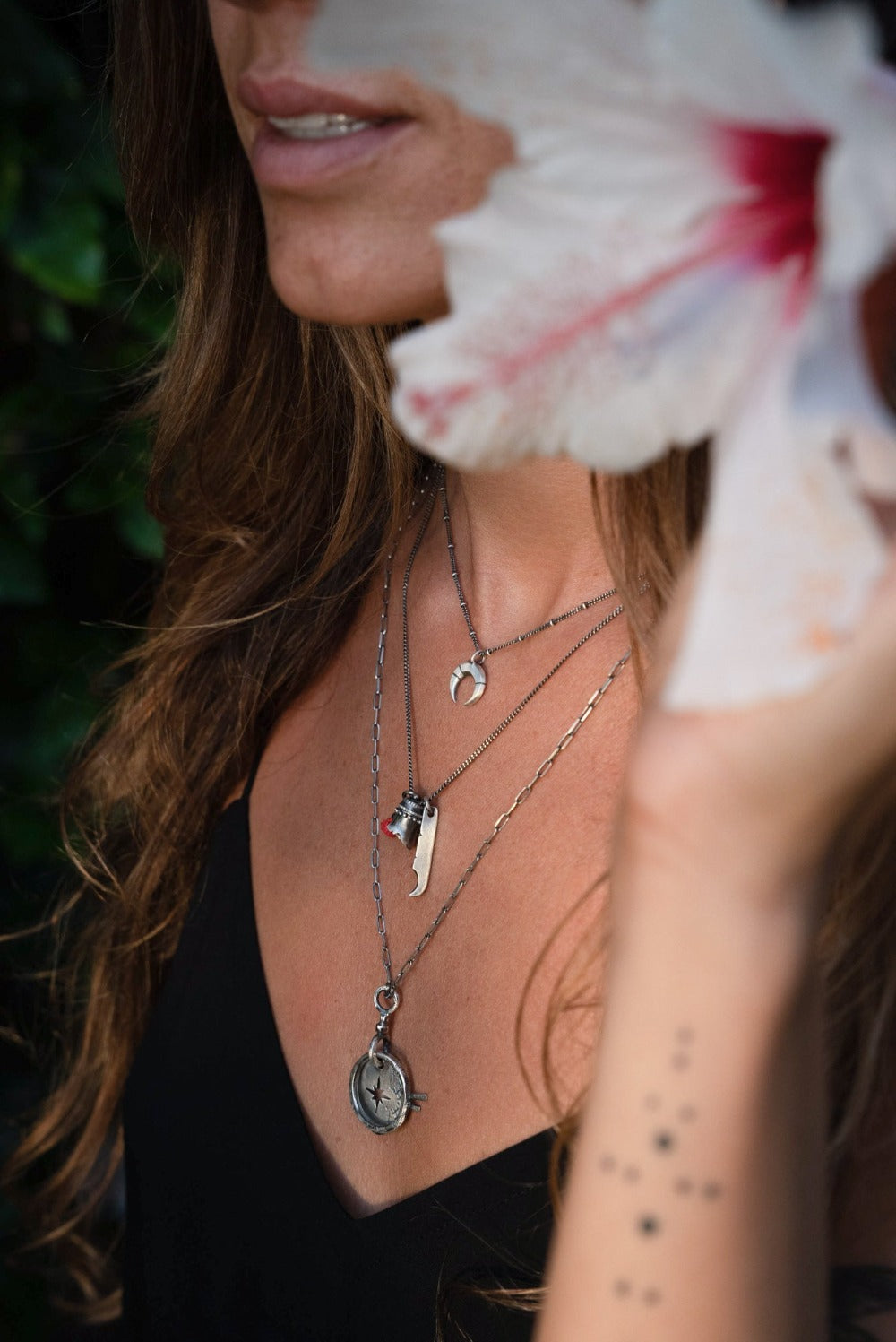 A silver necklace with a crescent-moon pendant and chain.