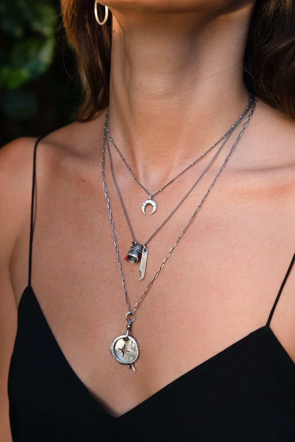 A silver necklace with a crescent-moon pendant and chain.