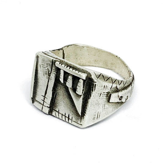 A silver-colored, oxidized and brushed finish ring with a geometric design, signet-style, on a white background.
