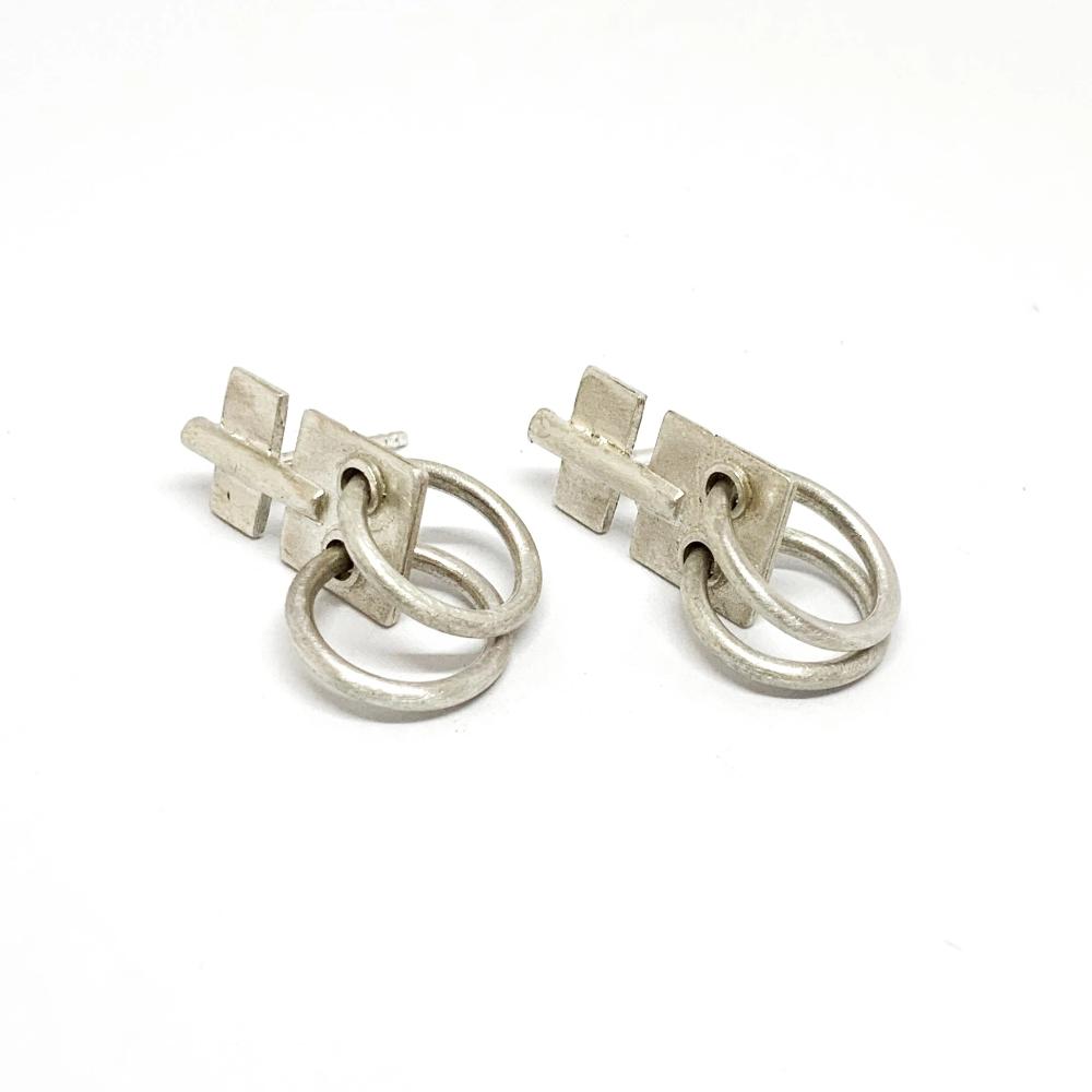 A pair of silver oxidized and brushed finish earrings with a geometric design