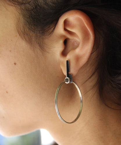 A pair of silver oxidized and brushed finish earrings with a geometric design