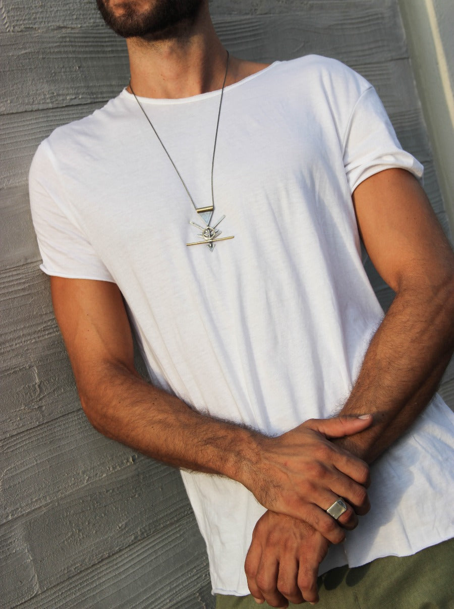 A silver and brass necklace with a geometric pendant, featuring a chain and a series of geometric shaped pendants attached to it.