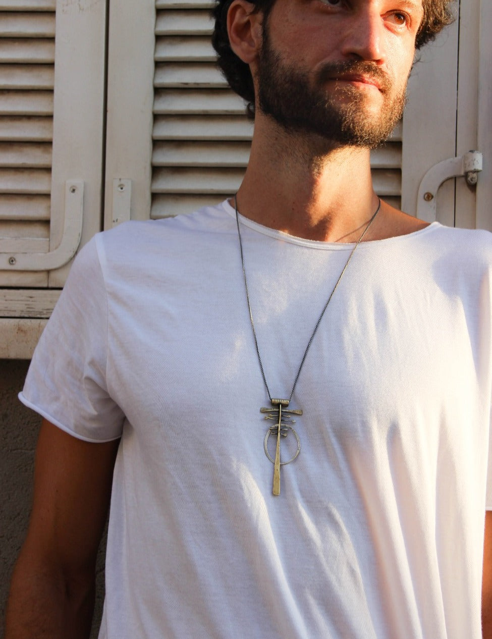 A silver and brass necklace with a geometric pendant