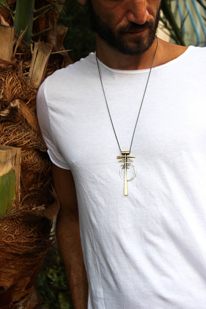 A silver and brass necklace with a geometric pendant