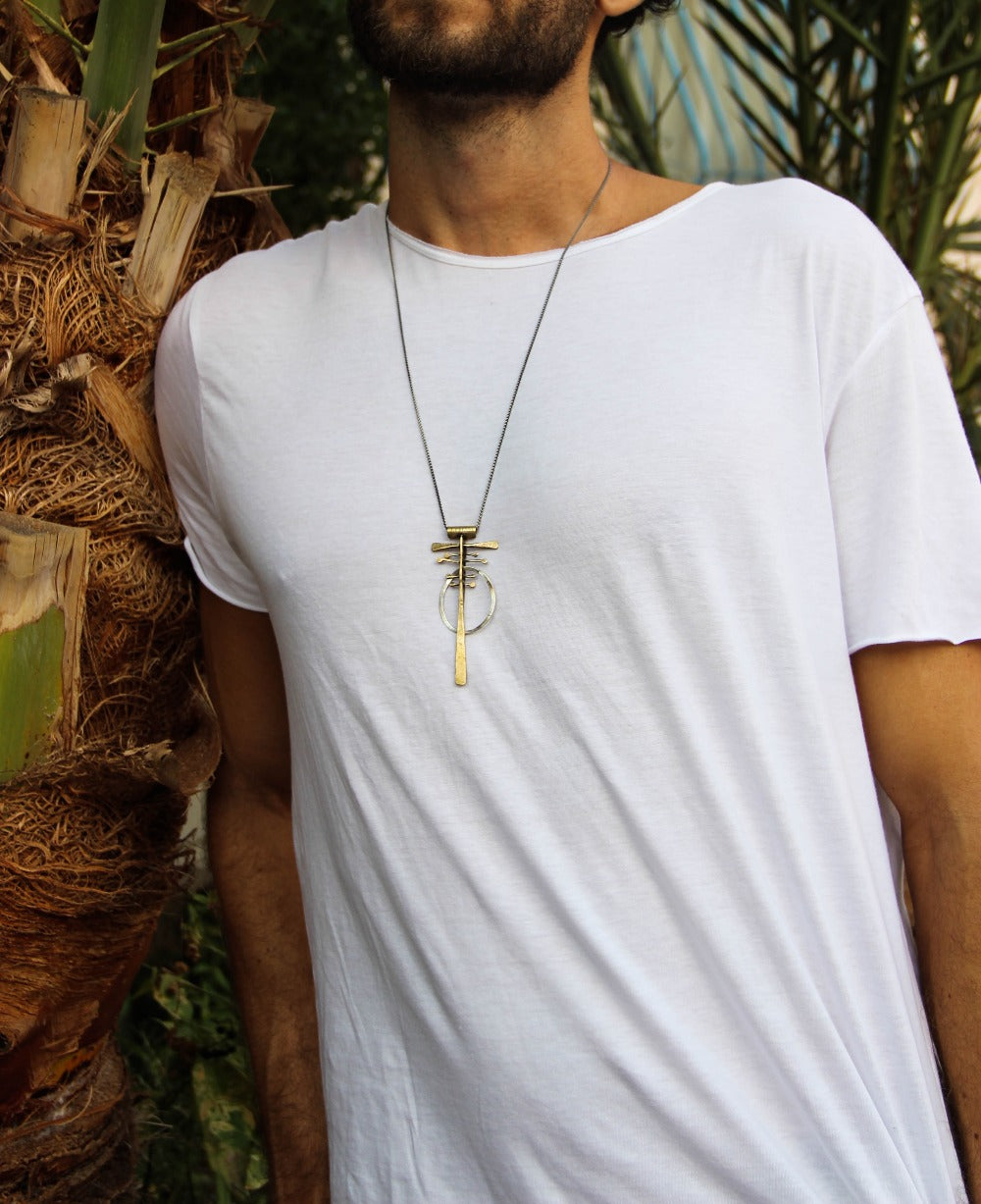 A silver and brass necklace with a geometric pendant