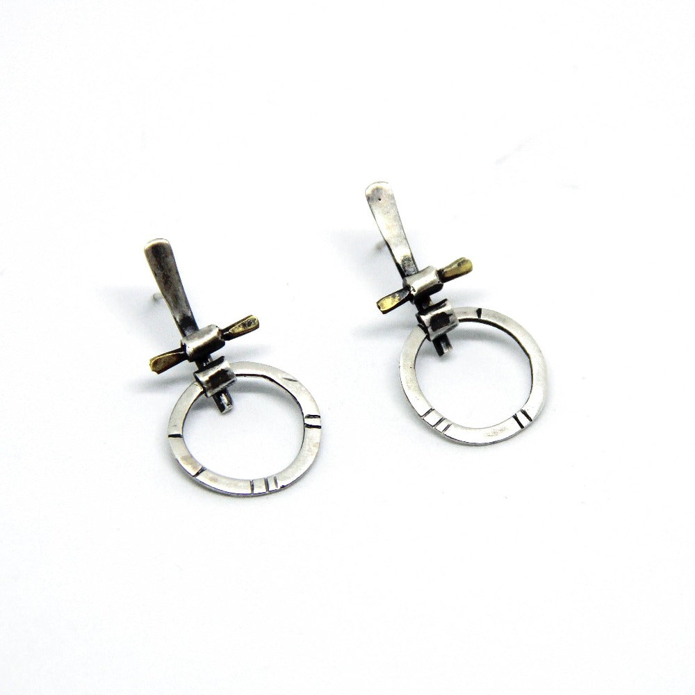 A pair of silver and brass earrings with a geometric design, displayed against a white background.