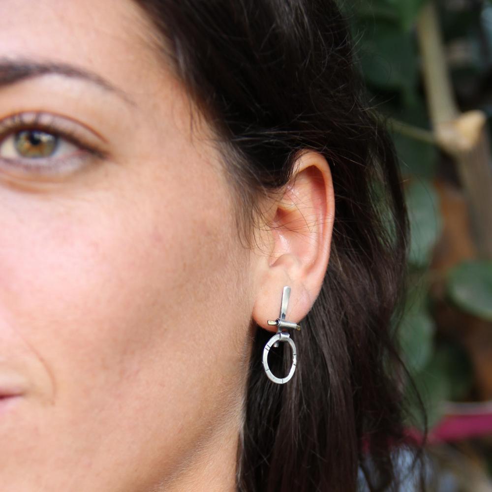 A pair of silver and brass earrings with a geometric design