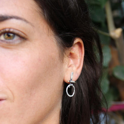 A pair of silver and brass earrings with a geometric design