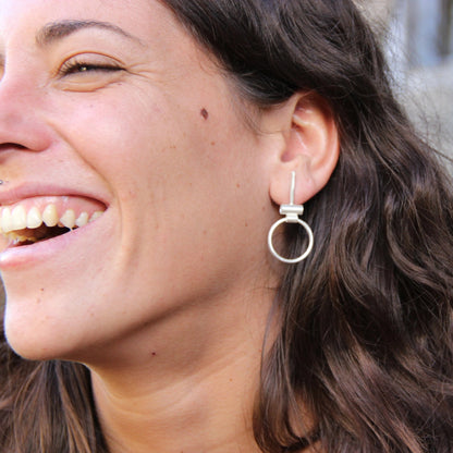A pair of silver hoop earrings with a brushed finish, featuring a simple and elegant design.