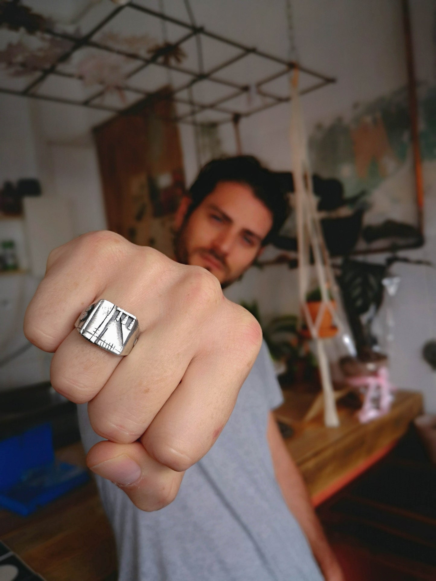 A silver, oxidized and brushed finish ring with a geometric design, signet-style