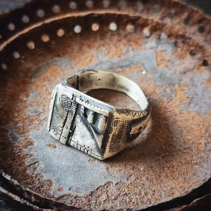 A silver, oxidized and brushed finish ring with a geometric design, signet-style