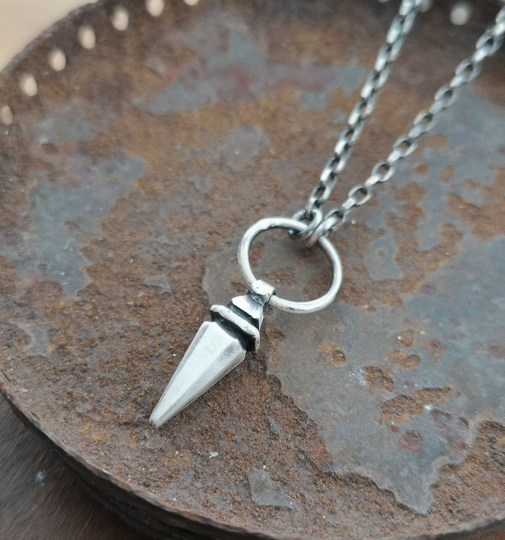 A sterling silver pendulum necklace with a brushed finish and a chain loop at the top.