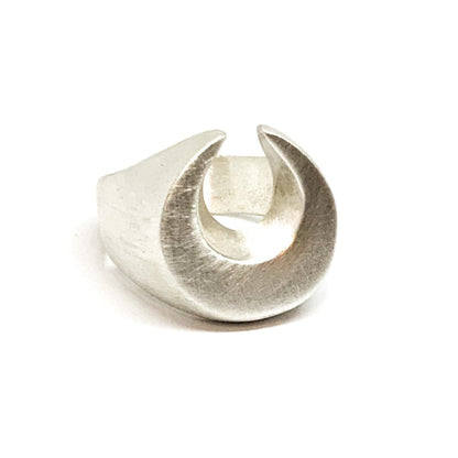 A silver signet ring with a brushed finish, featuring a crescent moon design.