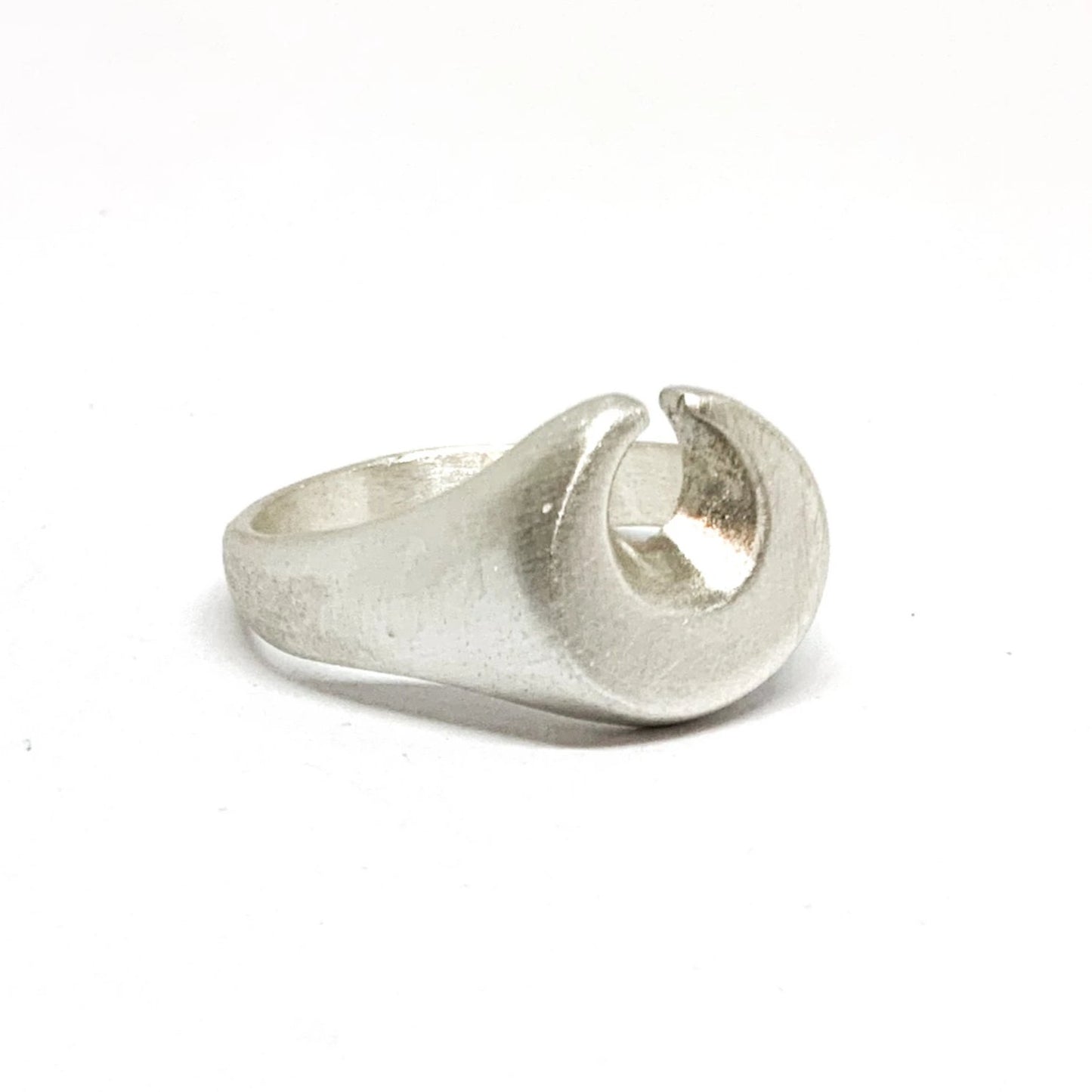 A silver ring featuring a brushed finish, handcrafted in the shape of a moon.