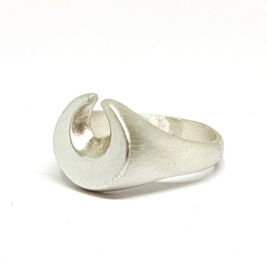 A silver ring featuring a brushed finish, handcrafted in the shape of a moon.