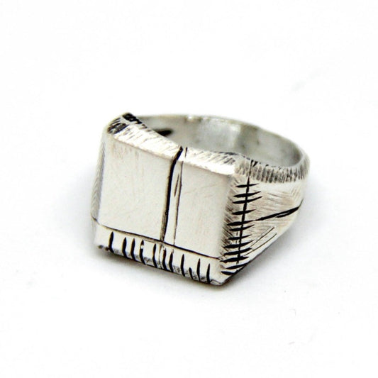 A silver carved memories ring with a textured and embossed pattern, displayed on a white background.