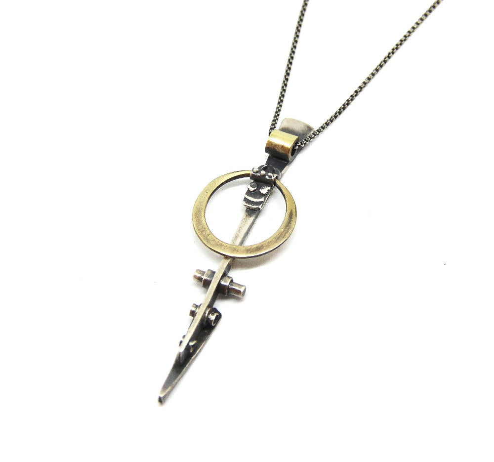 A silver necklace with a pendant featuring a ladder shape and a small cow symbol in the center, against a white background.