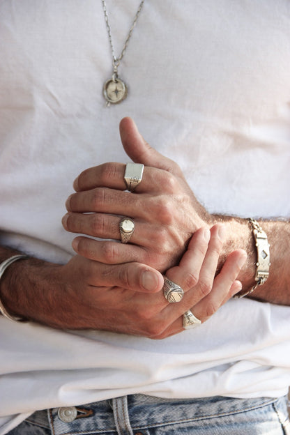 Men wearing silver shelly ganz rings: sun ring, nomad ring, maayan ring, carved memo ring and a silver bracelets