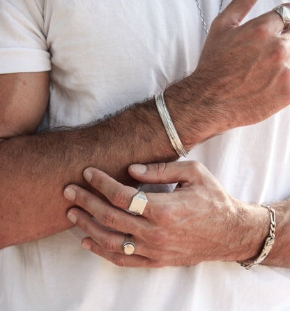 A silver carved memories ring with a textured and embossed pattern