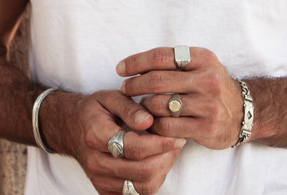 Men wearing silver shelly ganz rings: sun ring, nomad ring, maayan ring, carved memo ring and a silver bracelets