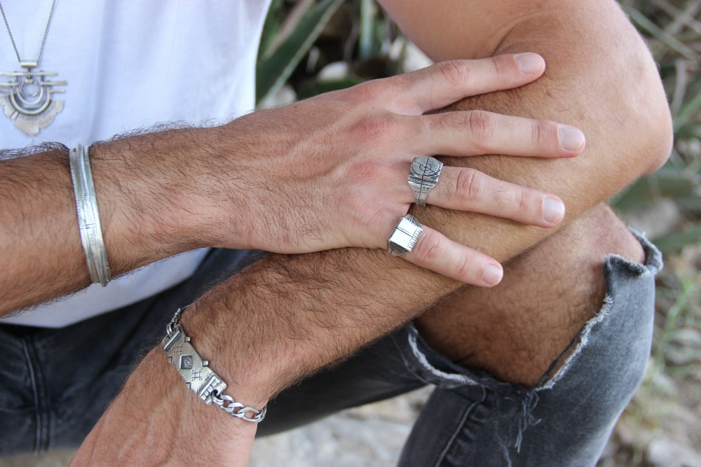 close up of man hands wearing target and carved memo rings 