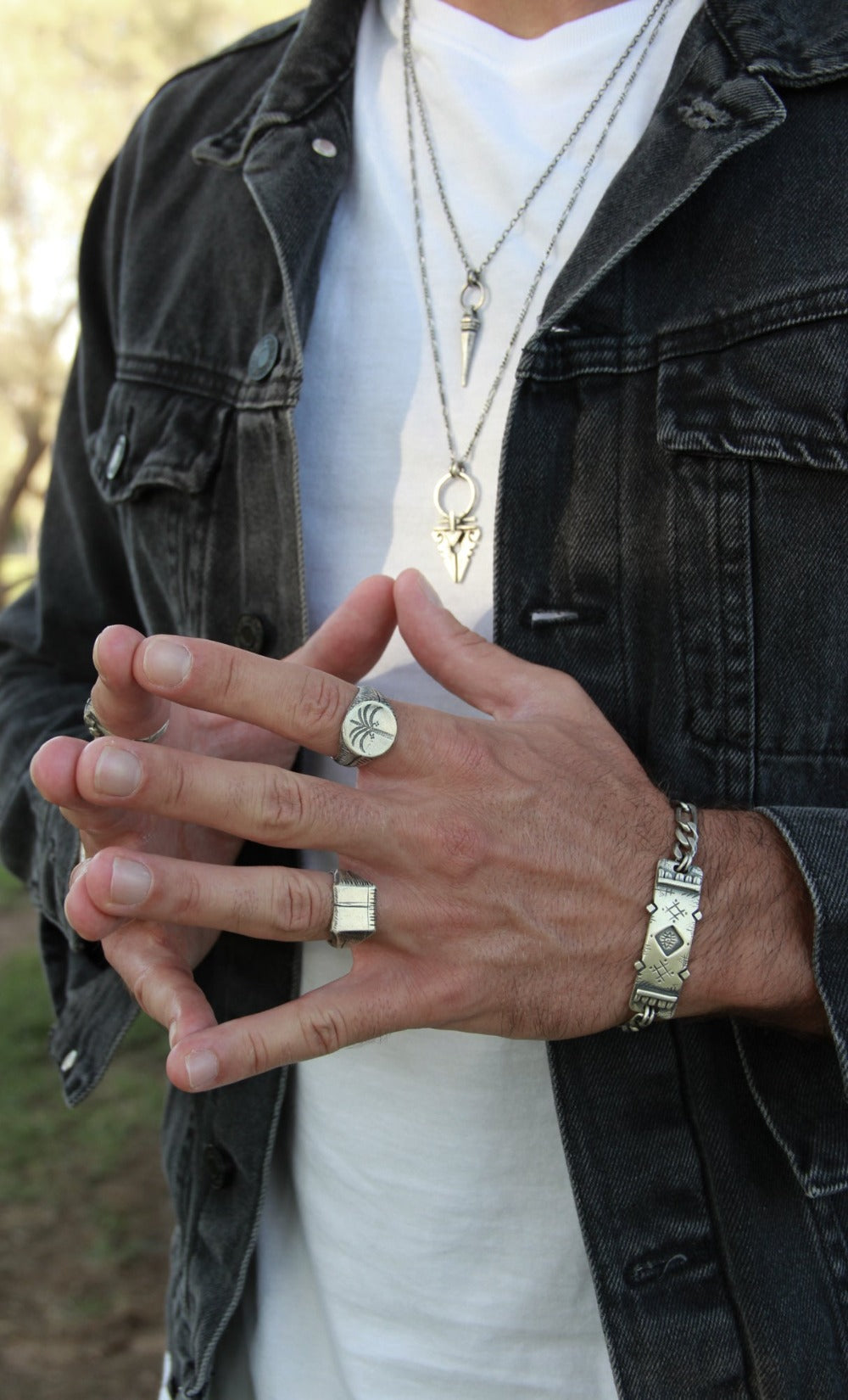 A silver ring with a brushed finish and a palm tree design on the top, signet-style.