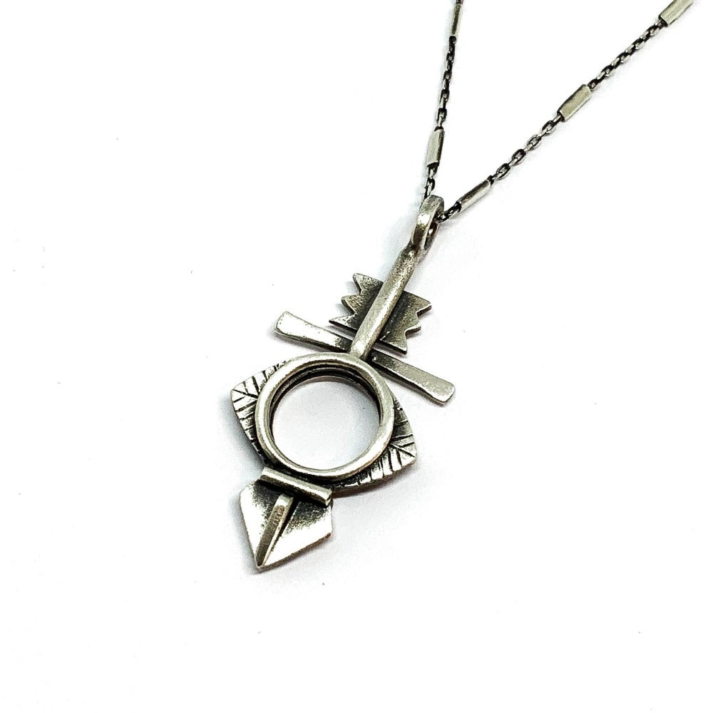 A silver necklace with a geometric-patterned pendant, featuring a combination of Morrocan and Mexican inspiration.