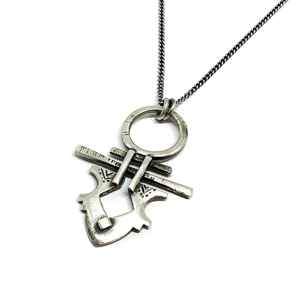 A silver necklace with a pendant featuring a stylized key design, on a white background.