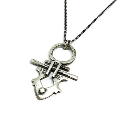 A silver necklace with a pendant featuring a stylized key design, on a white background.