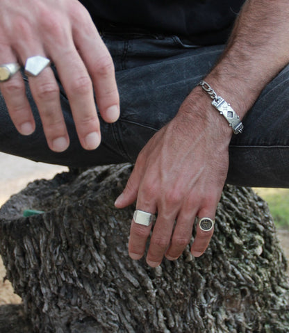 A silver carved memories ring with a textured and embossed pattern
