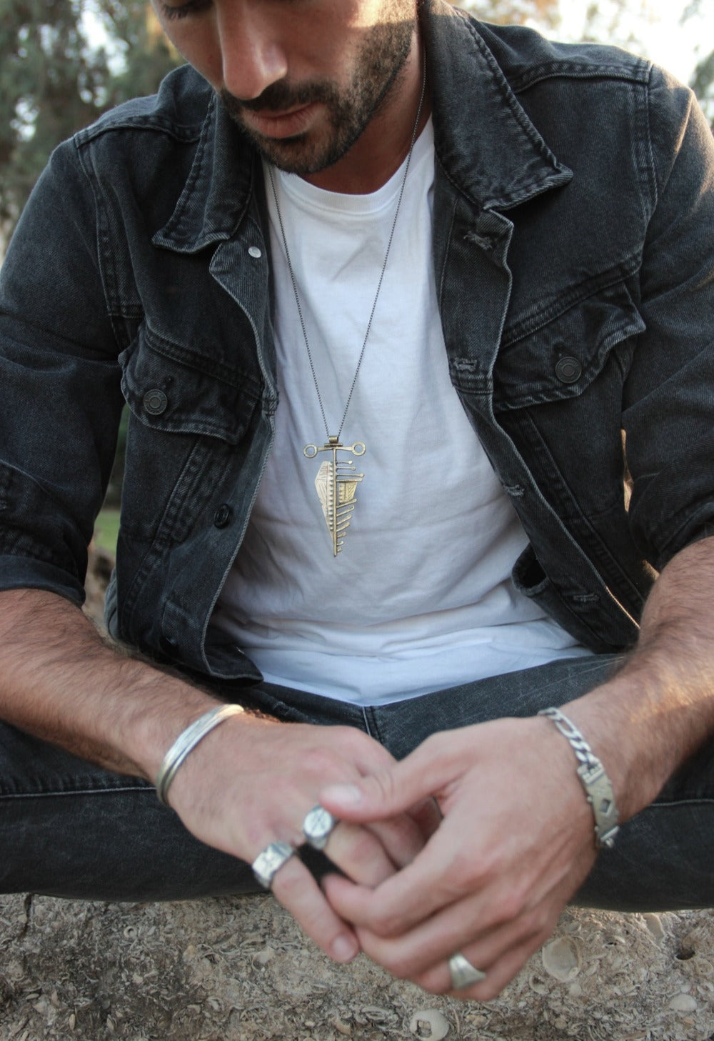 Men wearing silver shelly ganz rings: florence ring, nomad ring, and a silver bracelets