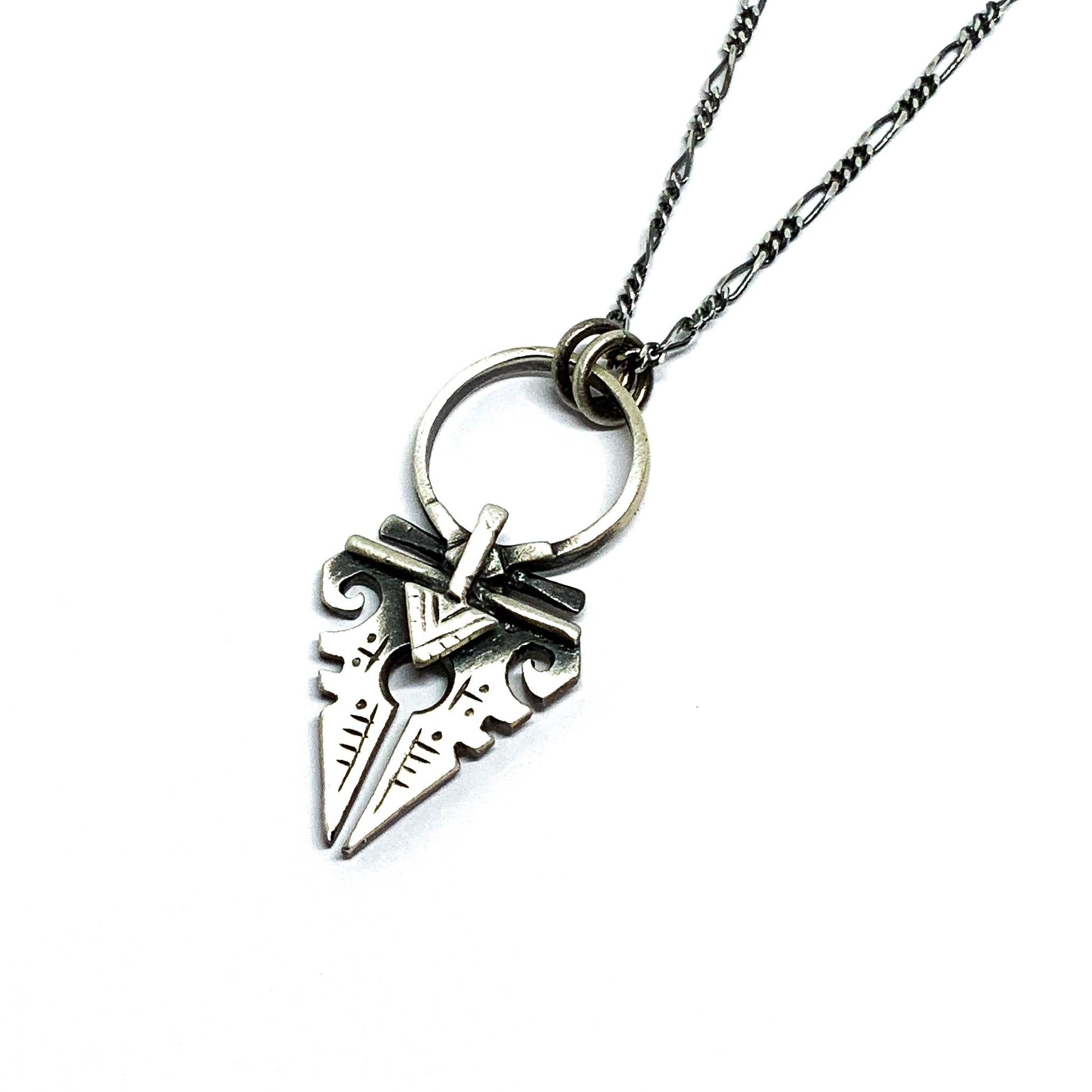 A sterling silver necklace with an oxidized and brushed finish, featuring a pendant with a strength symbol design.