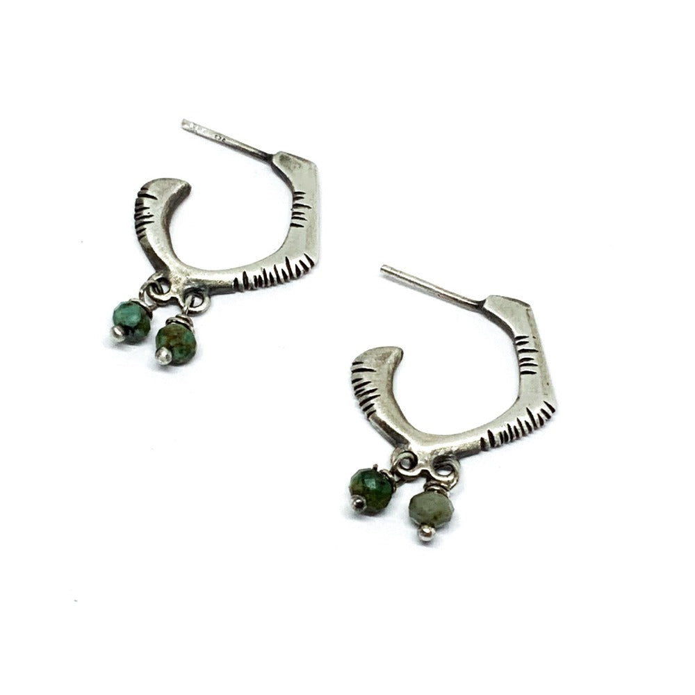 A pair of sterling silver oxidized and brushed finish earrings with turquoise accents and decorative stones.