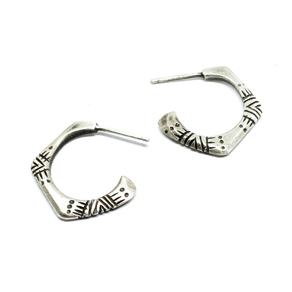A pair of silver oxidized and brushed finish earrings with a geometric pattern, handcrafted.
