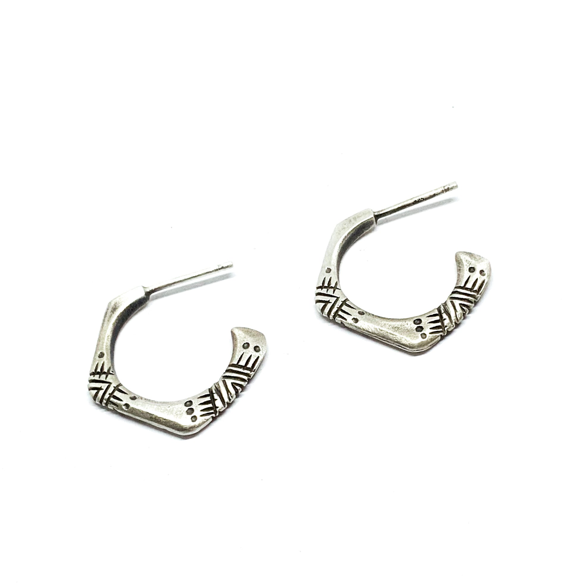 A pair of silver oxidized and brushed finish earrings with a geometric pattern, handcrafted.
